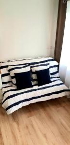 - un lit avec des oreillers en noir et blanc dans l'établissement Escapade Niortaise - Studios climatisés hyper-centre de Niort, à Niort