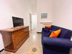a living room with a blue couch and a tv at Savona Casa Vacanze vicino Mare 3 minuti WIFI in Savona