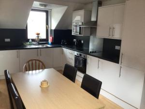 a kitchen with a wooden table with chairs and a table at The Coffee Pot accommodation in Dufftown