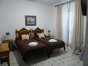 a bedroom with two beds with towels on them at Hotel Entreolivos in El Pedroso