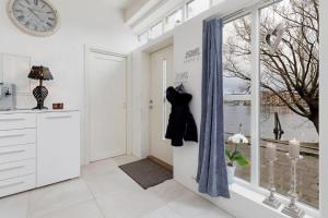 uma cozinha branca com uma porta com uma cómoda e uma janela em Stylish apartment with beautiful views of the river, beach nearby em Kristiansand
