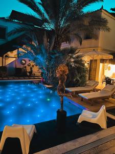una gran piscina con sillas y una palmera en The ABC Hotel, en Alacati