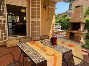 una mesa y sillas en un patio con chimenea en Villino a 200 mt dal mare, en Anzio