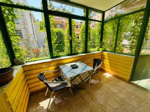 a table and chairs in a room with windows at Holiday Home Vesna in Budva