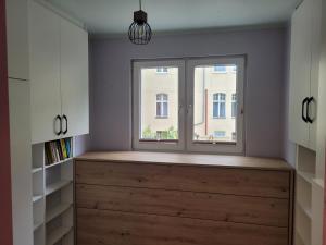 una ventana en una habitación con un cofre de madera en la parte delantera en Apartament Batorego 2a en Gdansk