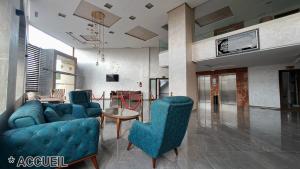 梅克內斯的住宿－Hotel Jaouharat Ismaili，客厅配有2把蓝色椅子和桌子