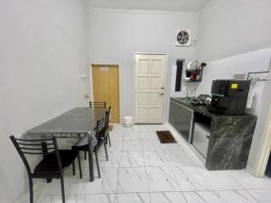 a kitchen and dining room with a table and chairs at Aufa Homestay 2 Bilik Aircond in Pendang