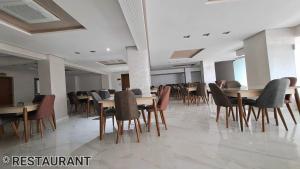 una sala da pranzo con tavoli e sedie in un edificio di Hotel Jaouharat Ismaili a Meknès