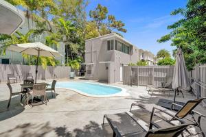 a backyard with a pool and chairs and a house at Art Deco Oasis by Las Olas in Fort Lauderdale