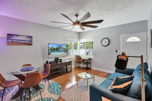 a living room with a blue couch and a ceiling fan at Art Deco Oasis by Las Olas in Fort Lauderdale