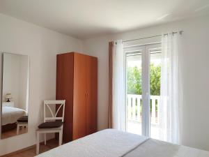 1 dormitorio con 1 cama y puerta corredera de cristal en House Kuna, en Brištane