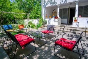 a patio with two chairs and a table with red cushions at Vintage Villa Saguramo 