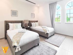 um quarto com 2 camas e uma janela em Luxury 3BR Private Villa and Elaborate Gardens em Dubai