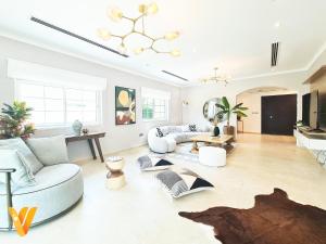 Luxury 3BR Private Villa and Elaborate Gardens في دبي: غرفة معيشة مع أريكة وطاولة