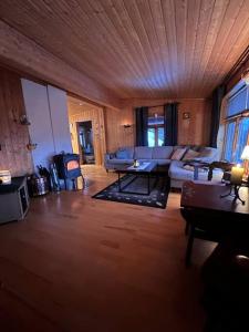 a living room with a couch and a table at Cozy and spacious cabin in Svensby