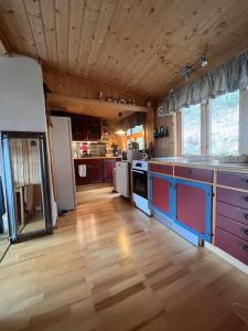Cozy and spacious cabin في Svensby: مطبخ كبير مع أرضية خشبية وعدادات