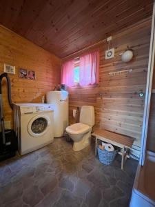 y baño con aseo y lavadora. en Cozy and spacious cabin, en Svensby