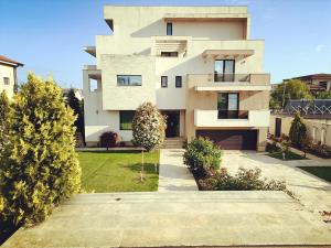 a large white building with a yard at Mamaia Moments Villa, Mamaia Nord in Mamaia Nord