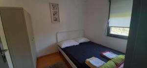 a small bed in a small room with a window at Apartman Olive grove in Rogoznica +17 photos