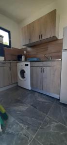 uma cozinha com uma máquina de lavar roupa e um frigorífico em Apartman Olive grove em Rogoznica