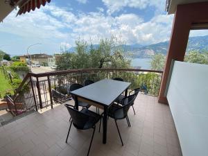stół i krzesła na balkonie z widokiem na wodę w obiekcie Villa Pifferi w mieście Malcesine