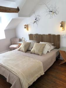 a bedroom with a large bed with a wooden headboard at Au Bonheur Dupré B&B in Montoire-sur-le-Loir