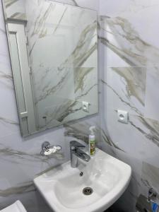 a white bathroom with a sink and a mirror at Hotel Sharl in Ninotsminda