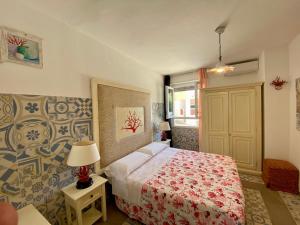 a bedroom with a bed with a red comforter at Casetta al mare in Isola Rossa