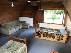 um quarto com uma cama e um sofá num quarto em Chalés Pesqueiro Sitio do Aconchego em Porto Feliz