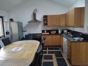 a kitchen with a wooden table and a counter top at Granny Cottage. in Marchin