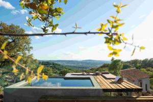 una piscina con terraza de madera junto a una casa en Vigias -Eternal Landscapes, en Marvão