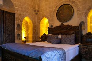 een slaapkamer met een groot bed in een kamer met bogen bij Ankahan Konağı in Mardin