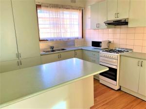 a kitchen with white cabinets and a counter top at Easy Self Check-in accomodation in Springvale