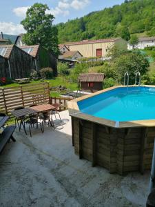 una grande piscina con tavolo, sedie e tavolo da picnic di Gite Eden a Saint-Maurice-sur-Moselle