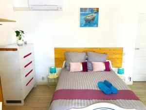sypialnia z łóżkiem z niebieskimi klapkami w obiekcie Blue Summer Vibes Apartment for 4P, AC, parking, beach at 50m, SPA access -1 w mieście La Ciotat