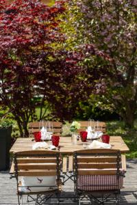 una mesa de madera con dos sillas alrededor con flores. en Boutique Skipass Superior Hotel, en Kranjska Gora