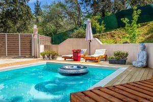 a swimming pool with a deck and an umbrella at Nightingale Villa & Suites Corfu in Gazátika