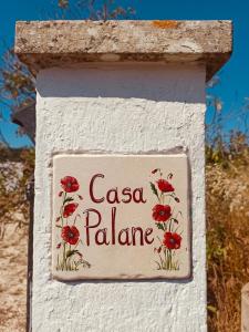 een bord op een muur met rode bloemen erop bij Casa Palane in Marina Serra