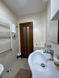 a white bathroom with a sink and a toilet at Apartament Bogdan in Gura Humorului