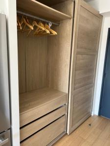 阿拉東的住宿－A la Nuitée, Grand studio design LE VINCI，一个带木门和木衣架的衣柜