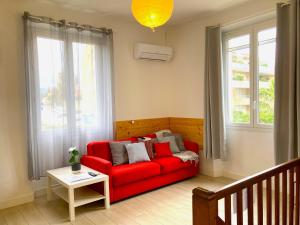 un divano rosso in un soggiorno con finestre di Blue Summer Vibes Duplex Studio for 4P, AC, sea view, parking, beach at 50m, SPA access -3 a La Ciotat