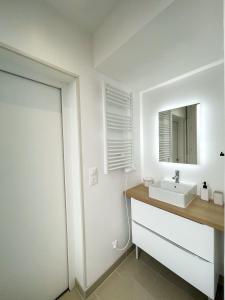 La salle de bains blanche est pourvue d'un lavabo et d'un miroir. dans l'établissement Hyper Centre, balcon, emplacement & vue incroyable, spacieux, à Amiens