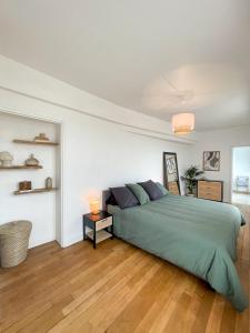 - une chambre blanche avec un lit vert dans l'établissement Hyper Centre, balcon, emplacement & vue incroyable, spacieux, à Amiens