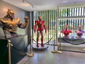 una habitación con estatuas de superhéroes expuestas frente a una ventana en Stardust Boutique Hotel en Hua Hin