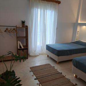 Un dormitorio con dos camas y una ventana. en Kokkari Social Club, en Kokkari