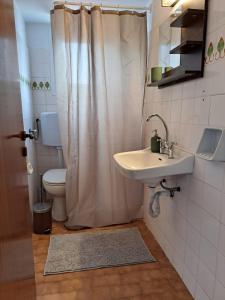 Un baño con lavabo, inodoro y ducha. en Kokkari Social Club, en Kokkari
