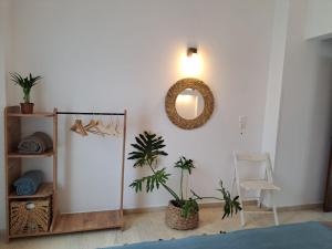 Un dormitorio con plantas, un espejo y una silla. en Kokkari Social Club, en Kokkari 2 fotos más
