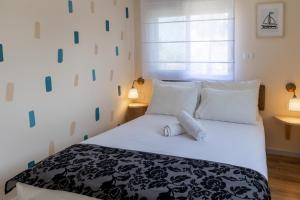 a bedroom with a black and white bed with white pillows at Domus Bat Galim Hotel in Haifa