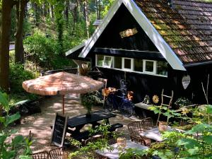 ein schwarzes Haus mit einem Tisch und Stühlen davor in der Unterkunft Studio Klein Schoorl in Schoorl