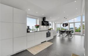 a kitchen with white cabinets and a dining table at Beautiful Home In Faaborg With Jacuzzi in Fåborg
